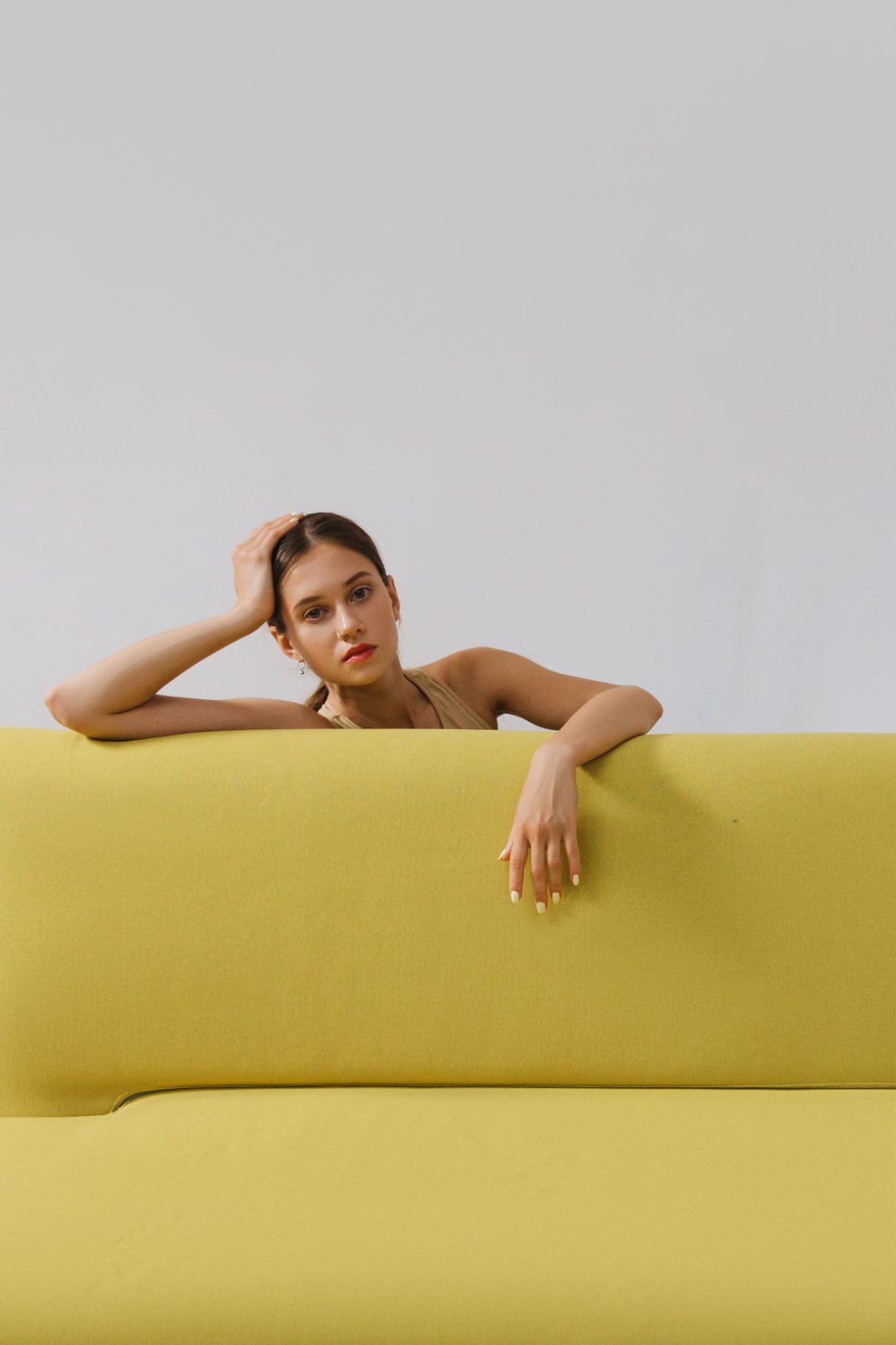 Woman leaning on a Yellow Sofa